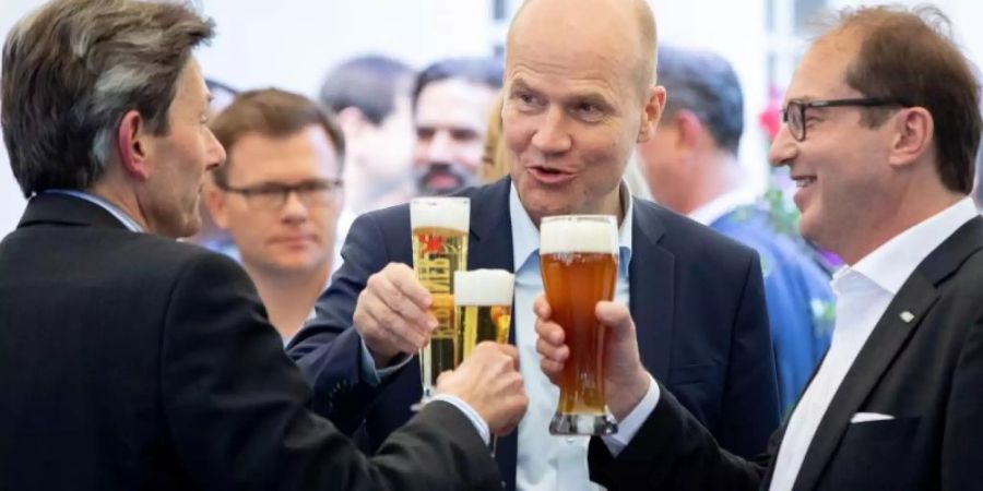 Rolf Mützenich (v.l.), kommissarischer Vorsitzender der SPD-Bundestagsfraktion, Unionsfraktionschef Ralph Brinkhaus und CSU-Landesgruppenchef Alexander Dobrindt stossen zu Beginn der Klausurtagung mit einem Bier an. Foto: Kay Nietfeld