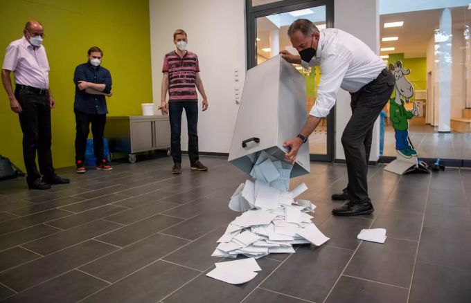 Wahlvorsteher Michael Gras leert eine Wahlurne zum Beginn der Auszählung von Stimmen bei der Landtagswahl von Sachsen-Anhalt in einer Schule in Magdeburg. Wahlen