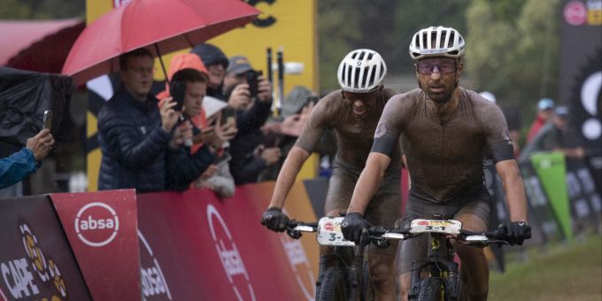 Nino Schurter (links) und Andri Frischknecht (rechts) erreichen das Ziel bei der sechsten Etappe des Absa Cape Epic 2023. EPA/KIM LUDBROOK ABSA Cape Epic 2023