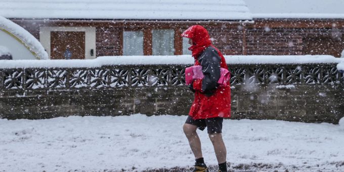 Ein Mann geht im nordenglischen Barnsley bei starkem Schneefall in seinen Shorts spazieren. Ein Mann geht im nordenglischen Barnsley bei starkem Schneefall in seinen Shorts spazieren.