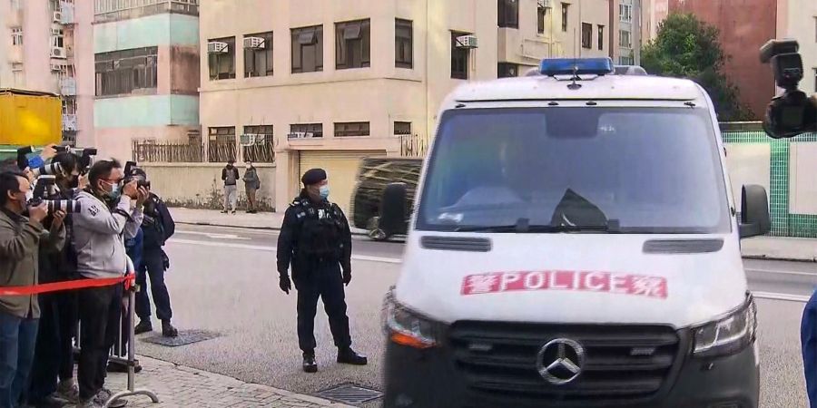 Ein Polizeiwagen, der mumasslich Angehörige des ermordeten Models Abby Choi transportiert und  vor dem Kowloon City Law Courts Building ankommt.