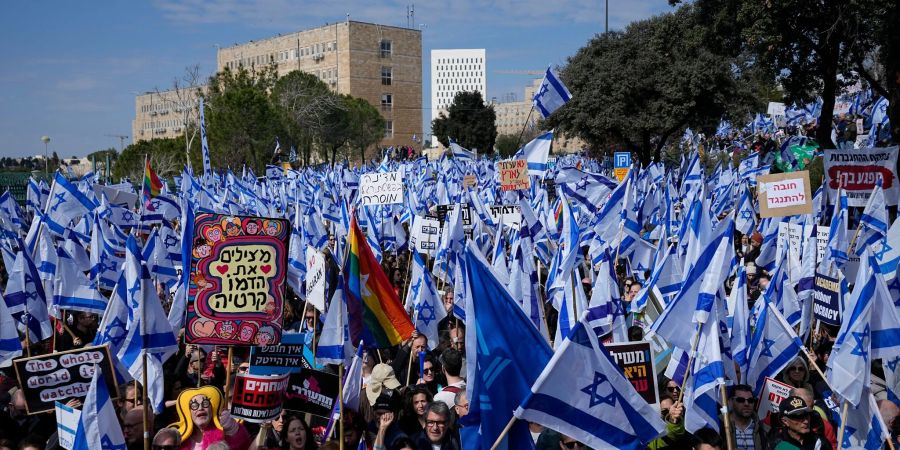 Auf einer Demonstration in Jeruslaem schwenken Protestierende isreaelische Nationalflaggen.