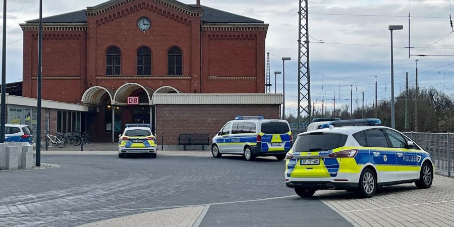 Polizeifahrzeuge vor dem Bahnhof in Guben. Ein Mann hat in einem Regionalzug in Brandenburg eine Jugendliche mit einem axtähnlichen Gegenstand verletzt.