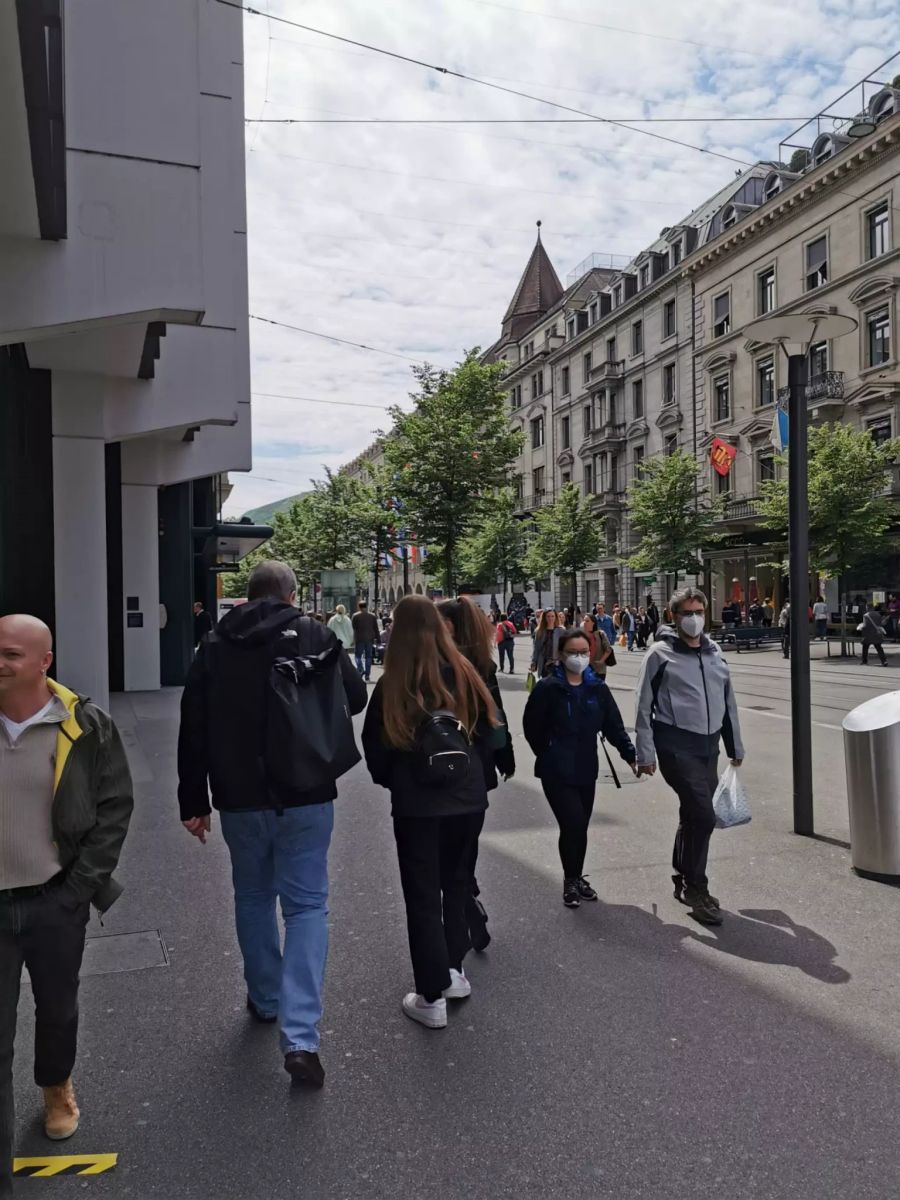 Die Menschen flanieren durch Zürichs Strassen.