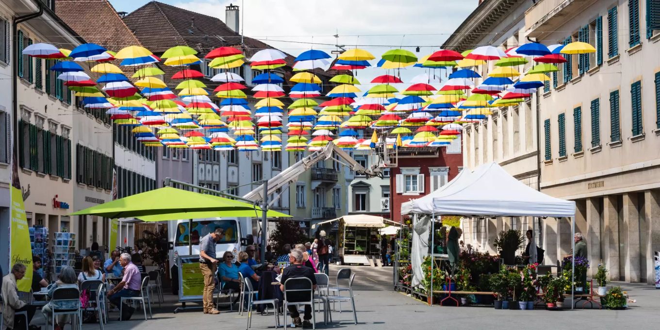 Farbenfrohes Schirmdach bringt Schatten in die Kirchgasse