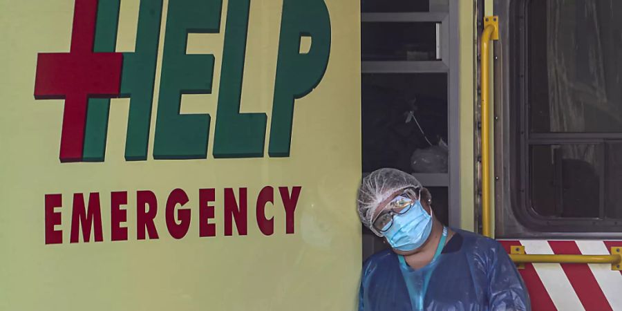 Ein medizinischer Mitarbeiter legt in Chiles Hauptstadt Santiago seinen Kopf gegen einen Krankenwagen. Foto: Esteban Felix/AP/dpa