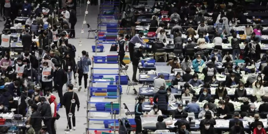 Mitglieder der Nationalen Wahlkommission zählen in einer Sporthalle in Seoul Stimmzettel aus. Foto: Ahn Young-Joon/AP/dpa