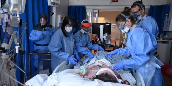 Spitalmitarbeiter in Schutzkleidung betreuen einen Patienten. Coronavirus Papworth Hospital