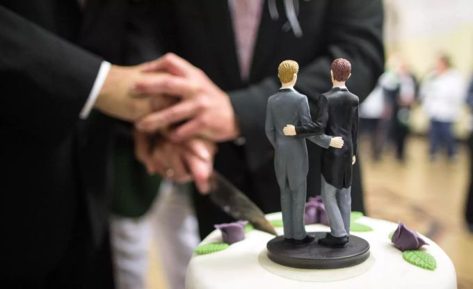 Zwei Männer schneiden nach ihrer Eheschliessung im Rathaus eine Hochzeitstorte an. Ehe für Alle
