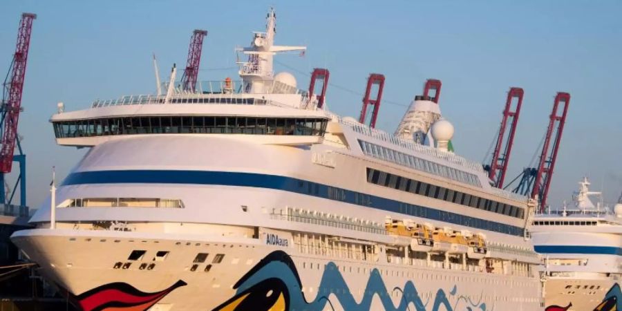 Die beiden Aida-Kreuzfahrtschiffe «Aidaaura» und «Aidacara» (r) liegen am Kreuzfahrt-Terminal Steinwerder in Hamburg. Foto: Christian Charisius/dpa