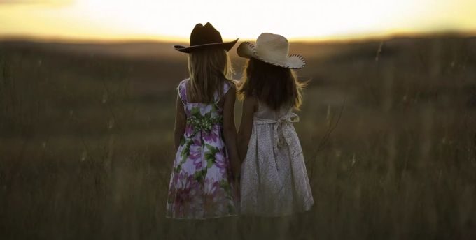 Zwei Mädchen stehen auf einem Feld. Kinderlose Paare können durch die Nutzung einer Spende von Samen Kinder bekommen. Zwei Mädchen auf Feld