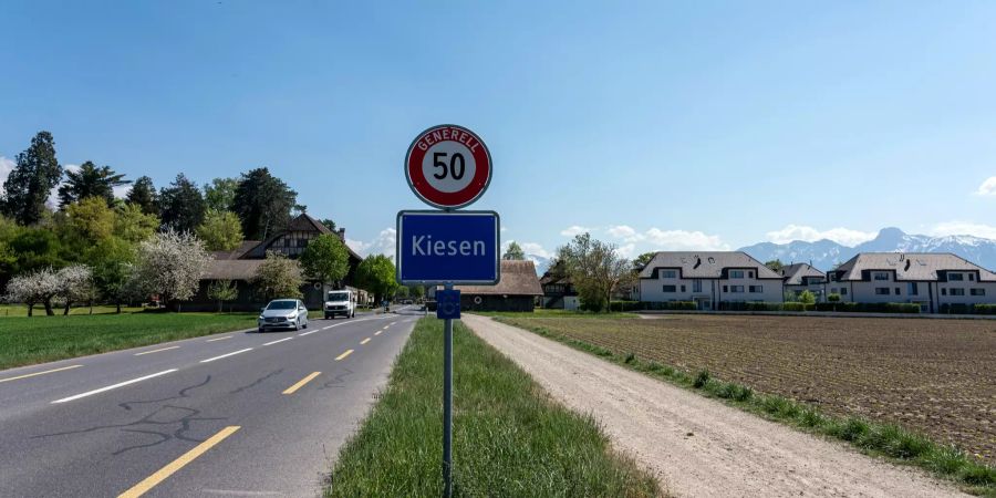 Kantonsstrasse mit Ortsschild von Kiesen.