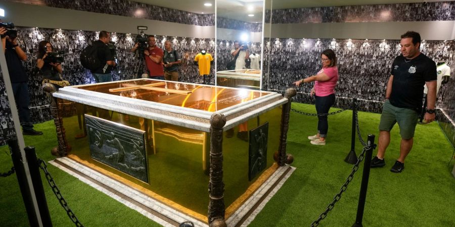 Fans stehen neben dem Grab des verstorbenen brasilianischen Fussballstars Pele im Mausoleum des Necropole Ecumenica Memorial Cemetery.
