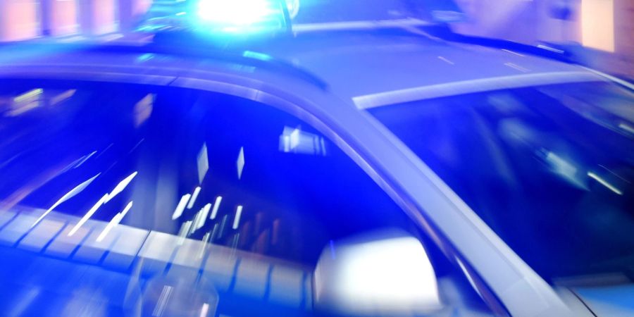 Ein Streifenwagen der Polizei steht mit eingeschaltetem Blaulicht auf einer Strasse. Eine Gruppe Männer hat in Hamburg auf einen 31-Jährigen geschossen. (Archivbild)