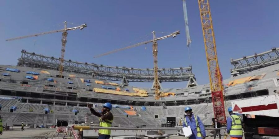 Bauarbeiter arbeiten am Lusail-Stadion in Katar. Foto: Hassan Ammar/AP/dpa/Archiv