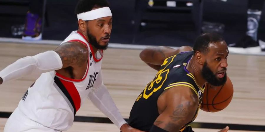 LeBron James (r) von den Los Angeles Lakers und Carmelo Anthony von den Portland Trail Blazers in Aktion. Foto: Kevin C. Cox/Pool Getty Images/AP/dpa