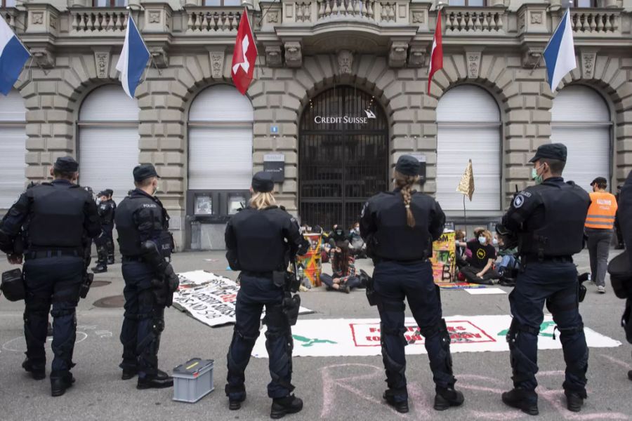 Polizisten stehen um die Klimaaktivisten vor dem Eingang der Credit Suisse am Paradeplatz in Zürich.