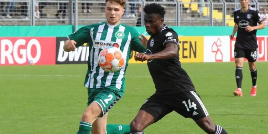 Düsseldorfs Kelvin Ofori (r) kommt gegen Oldenburgs Tassilo Thiele zum Schussversuch. Foto: Piet Meyer/dpa