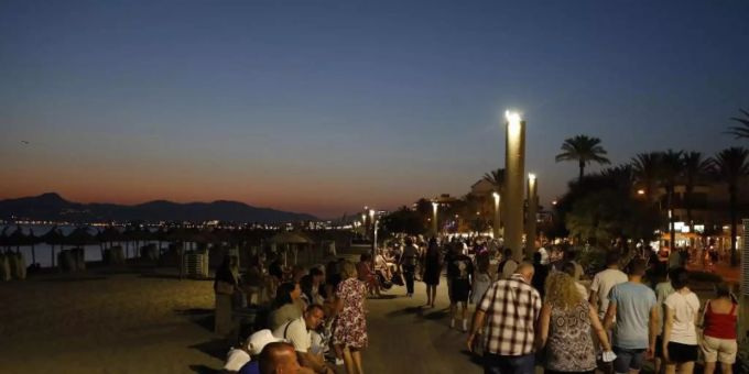 Menschen vergnügen sich abends an der Strandpromenade von Palma. Foto: Clara Margais/dpa Menschen vergnügen sich abends an der Strandpromenade von Palma. Foto: Clara Margais/dpa