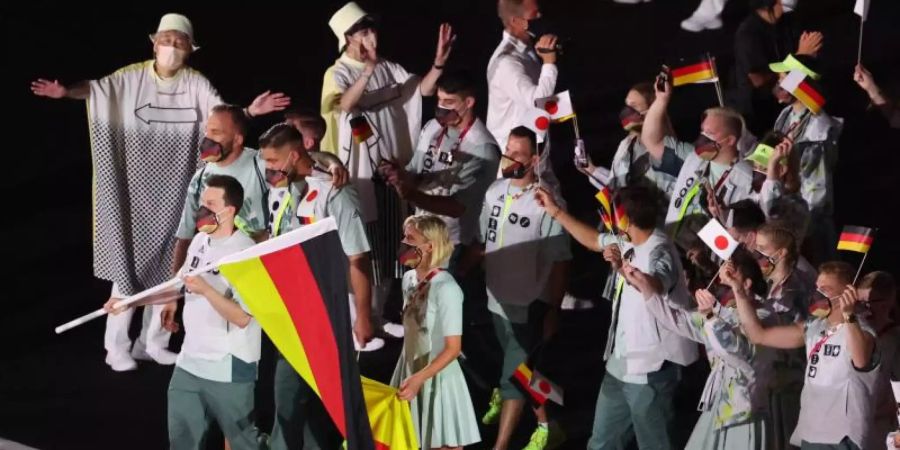 Patrick Hausding (l) durfte gemeinsam mit Beachvolleyballspielerin Laura Ludwig die deutsche Fahne ins Stadion tragen. Foto: Jan Woitas/dpa-Zentralbild/dpa