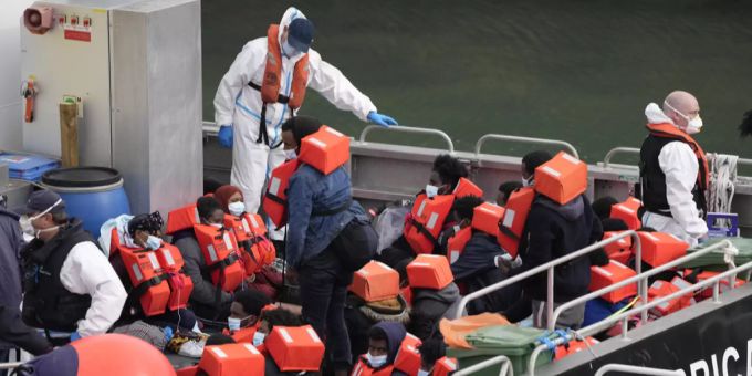 Migranten sitzen auf einem Schiff der Küstenwache. Ärmelkanal