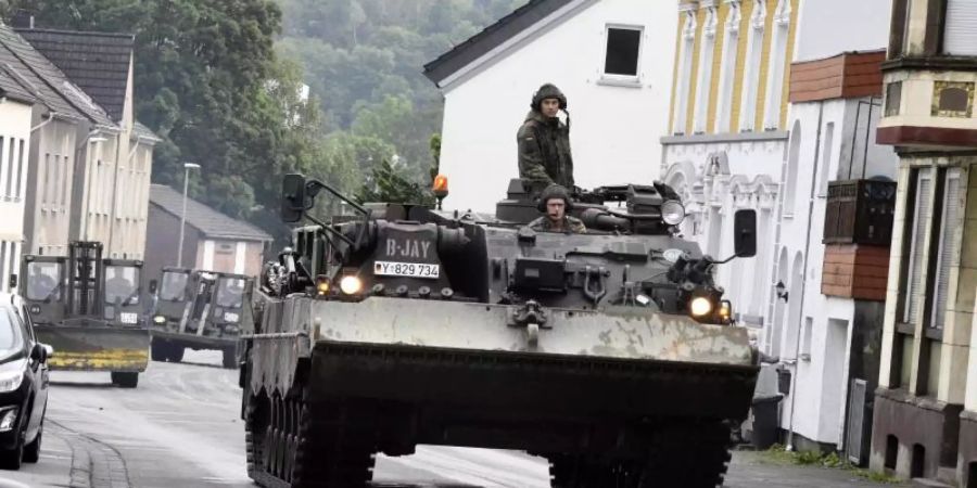 Mit einem Bergepanzer und schwerem Räumgerät rückt die Bundeswehr an, um die Schäden die die Überflutung der Nahmer am Vorabend mit sich gebracht hat, zu beseitigen. Foto: Roberto Pfeil/dpa