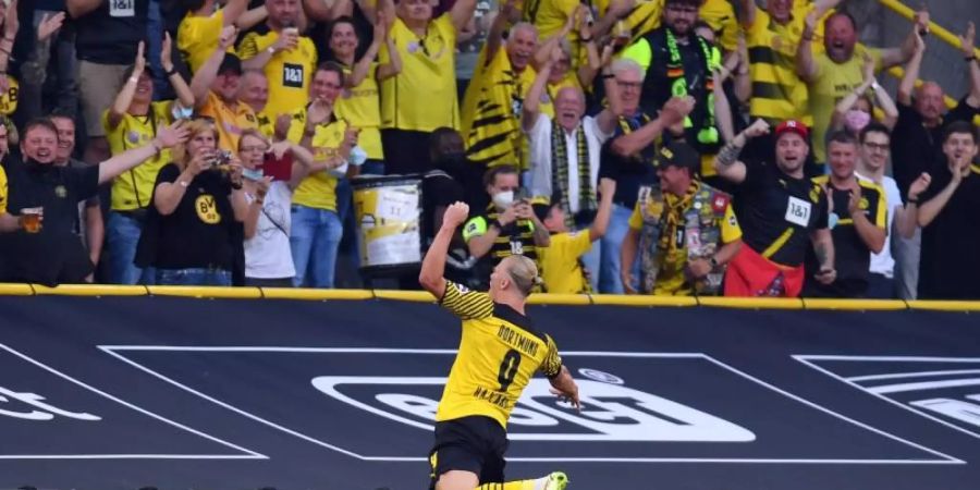 Dortmunds Erling Haaland springt jubelnd in Richtung Fans. Foto: Marius Becker/dpa