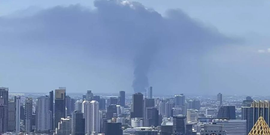 Rauch hinter der Skyline von Bangkok auf. In Thailand ist es in einer Chemiefabrik zu einer schweren Explosion gekommen. Foto: Tina Liu/AP/dpa