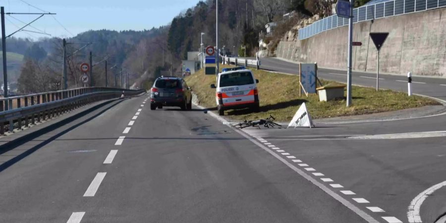 Fahrrad liegt beschädigt auf der Fahrbahn, Polizeiauto, Unfallfahrzeug
