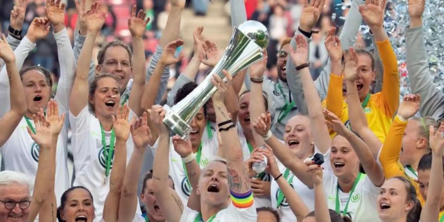 Wolfsburgs Nilla Fischer streckt im Beisein von Bundespräsident Frank-Walter Steinmeier den DFB-Pokal in die Höhe. Foto: Federico Gambarini