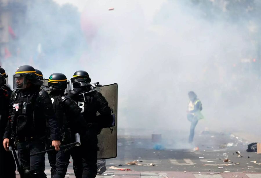 Ein Demonstrant kickt eine Tränengaskartusche weg.