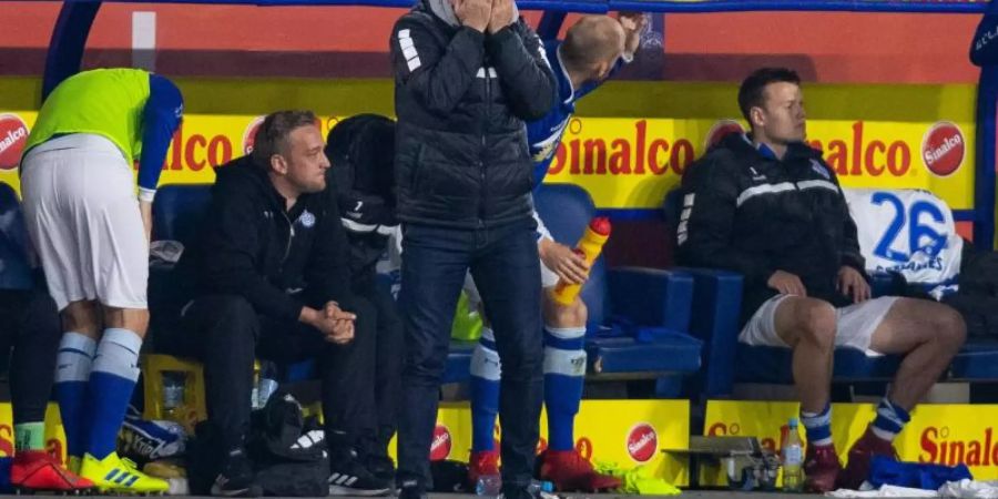 Duisburgs Trainer Torsten Lieberknecht steht beim Spiel gegen Bielefeld an der Trainerbank und schlägt die Hände vor das Gesicht. Foto: Guido Kirchner/dpa