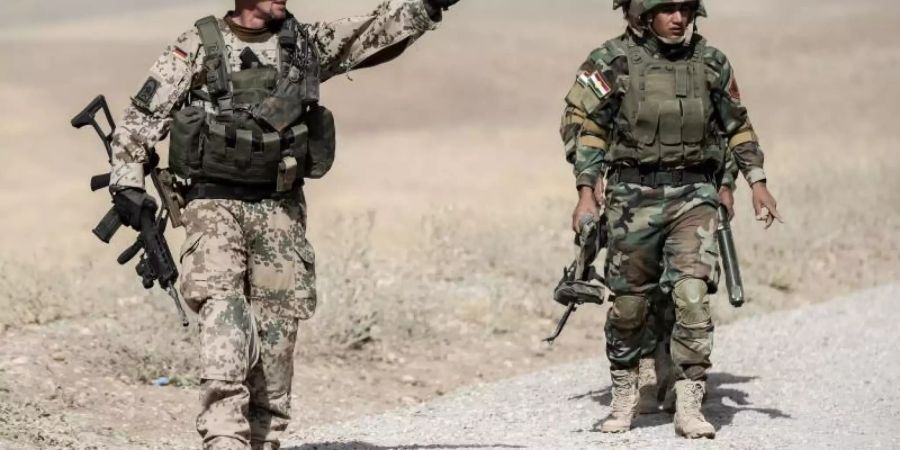 Ein Bundeswehrsoldat und kurdische Peshmerga im irakischen Erbil. Foto: Michael Kappeler/Archiv