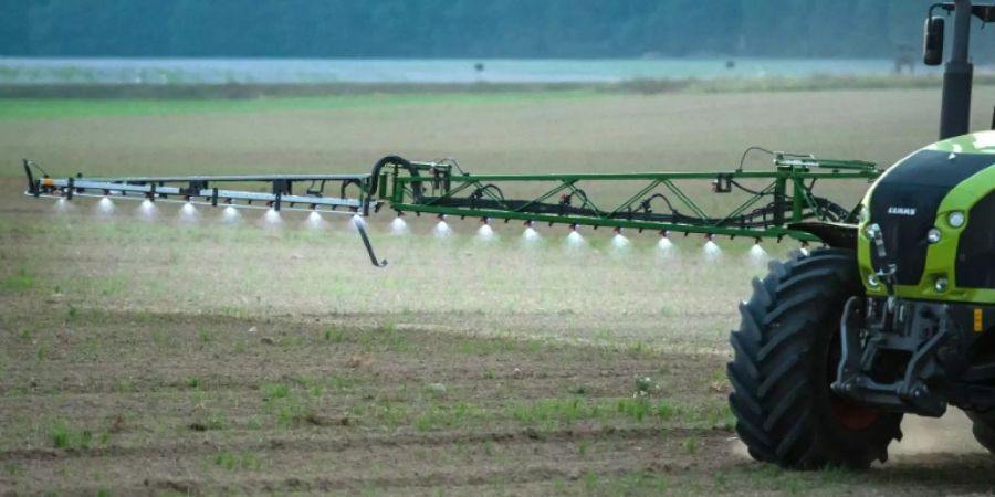 Landwirt fährt mit Spritze über Feld