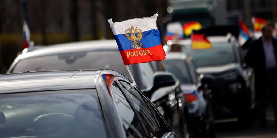 Russische Flaggen wehen an einem Auto vor dem Berliner Olympiastadion. Mit Blick auf pro-russische Demonstrationen fordern Innenpolitiker ein striktes Durchgreifen der Polizei bei Verstössen gegen Auflagen oder Gesetze.