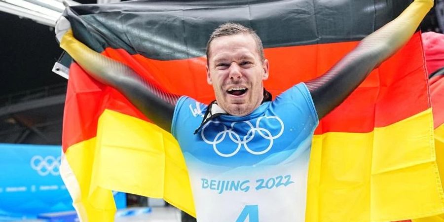 Skeletonpilot Christopher Grotheer jubelt über den Olympiasieg. Foto: Michael Kappeler/dpa