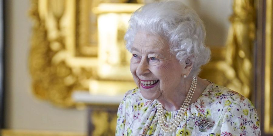 Die britische Königin Elizabeth II. lächelt, als sie im White Drawing Room von Schloss Windsor eine Ausstellung von Artefakten des britischen Kunsthandwerksunternehmens Halcyon Days besichtigt.