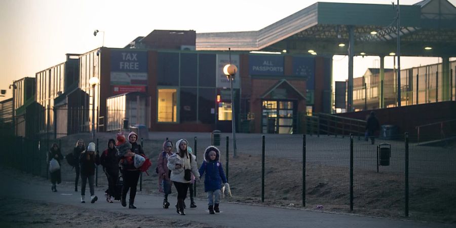 Flüchtlinge aus der Ukraine kommen am Grenzübergang in Polen an. Foto: Sebastian Gollnow/dpa