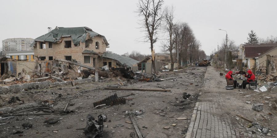 Ein Bild, das während eines von den Kiewer Behörden organisierten Besuchs in Butscha aufgenommen wurde, zeigt eine Gesamtansicht einer Strasse mit zerstörten russischen Militärmaschinen.