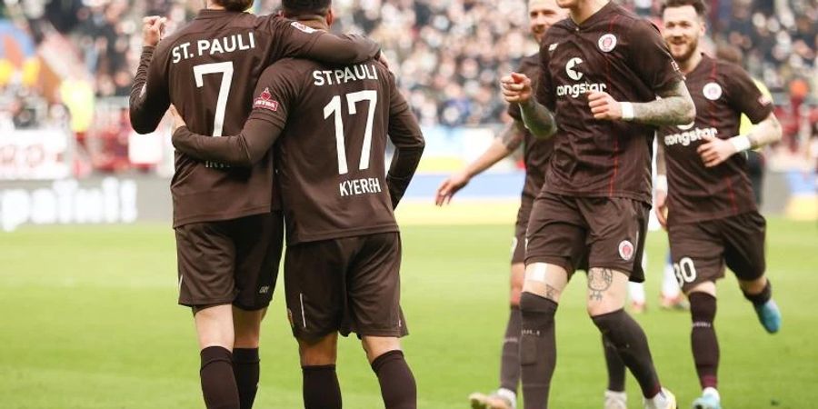 Spieler vom FC St. Pauli feiern das zwischenzeitliche 2:0. Foto: Christian Charisius/dpa