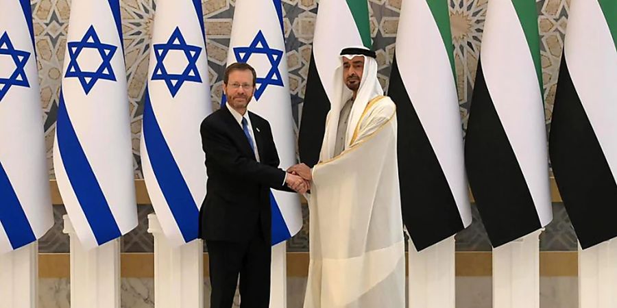 HANDOUT - Izchak Herzog (l), Präsident von Israel, und Scheich Abdullah bin Zayed Al Nahyan, Aussenminister der VAE, schütteln sich vor ihrem Treffen die Hände. Herzog ist am Sonntag als erster israelischer Präsident zu einem Besuch in die Vereinigten Arabischen Emirate (VAE) gereist. Foto: Amos Ben Gershom/GPO/dpa - ACHTUNG: Nur zur redaktionellen Verwendung und nur mit vollständiger Nennung des vorstehenden Credits