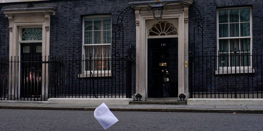 Eine Kopie des Berichts zu den mutmasslichen Lockdown-Verstössen im britischen Regierungssitz fliegt an der Eingangstür der 10 Downing Street vorbei.