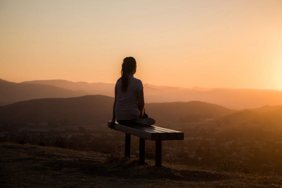 Frau schaut in Sonnenuntergang