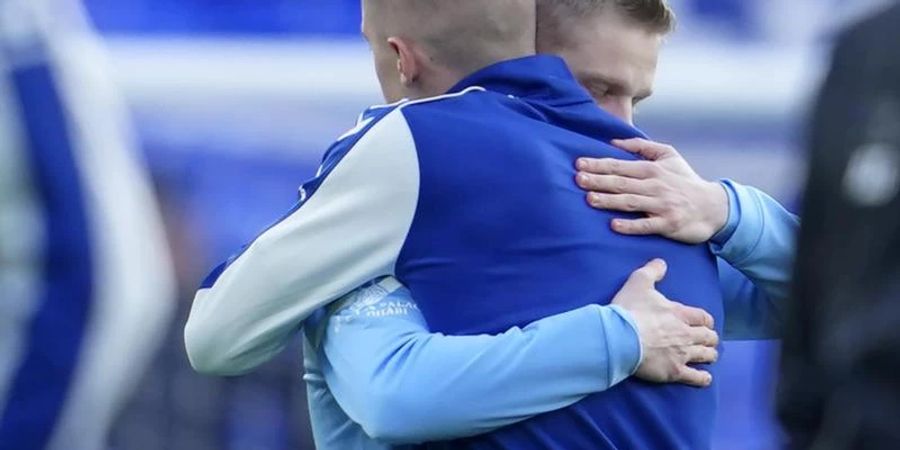 Die Ukrainer Alexander Zinchenko (l) von Manchester City und Vitali Mykolenko vom FC Everton umarmen sich vor dem Spiel. Foto: Jon Super/AP/dpa