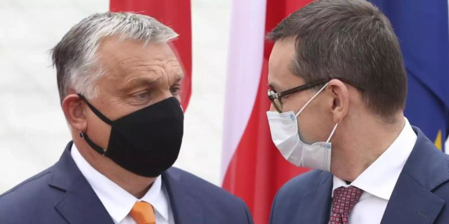 Polens Premierminister Mateusz Morawiecki begrüsst seinen ungarischen Amtskollegen Viktor Orban. Eine Mehrheit der EU-Staaten hat ungeachtet von Drohungen aus Ungarn und Polen ein Verfahren zur Bestrafung von Verstössen gegen die Rechtsstaatlichkeit innerhalb der Union auf den Weg gebracht. Foto: Czarek Sokolowski/AP/dpa