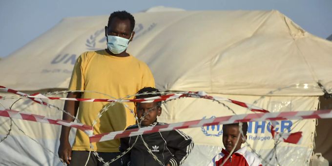 Ein Migrant steht mit zwei Kindern vor einem Stacheldrahtzaun im neu errichteten temporären Flüchtlingslager in Kara Tepe. (Archivbild) kara tepe