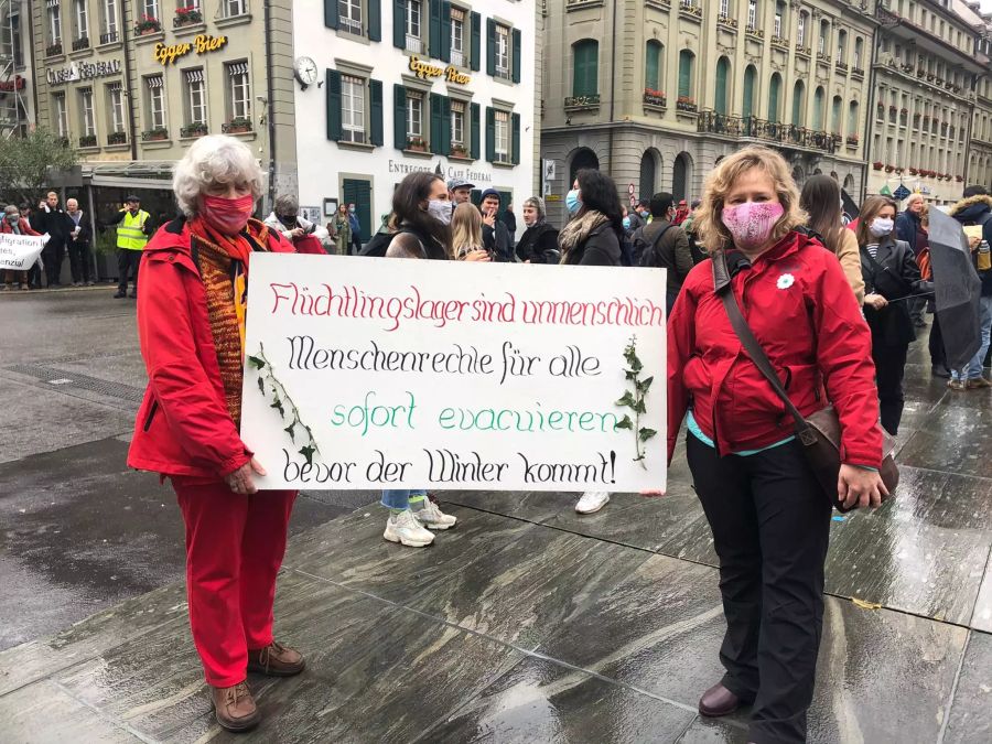 Demonstranten halten an der heutigen Demo auf dem Bundesplatz ihre Plakate in die Kamera.