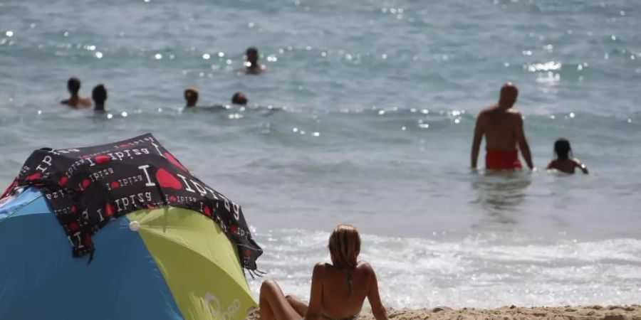 Eine Frau sonnt sich am Strand von Cala Major. Foto: Clara Margais/dpa