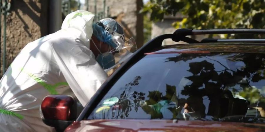 Prag: Ein junger Autofahrer wird an einer Drive-in-Teststation auf Covid-19-Symptome geprüft. In Tschechien breitet sich das Coronavirus weiter rasant aus. Foto: Petr David Josek/AP/dpa