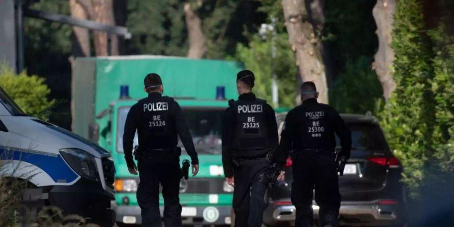 Polizeibeamte sind im Rahmen einer Durchsuchung auf einem Grundstück in Brandenburg unterwegs. Foto: Paul Zinken/dpa-Zentralbild/dpa